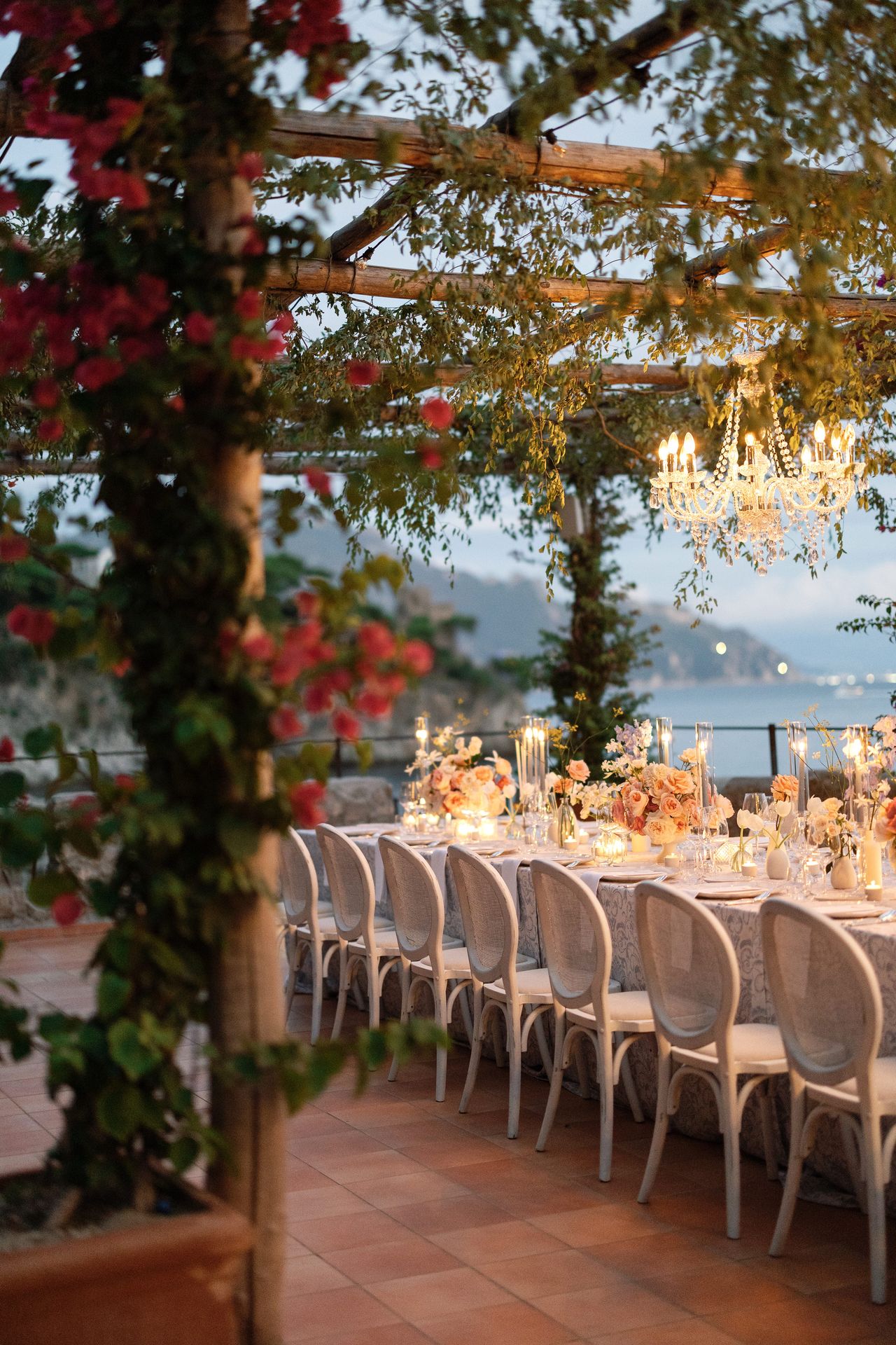 Luxury wedding table setting with blue patterned linens and elegant chandeliers